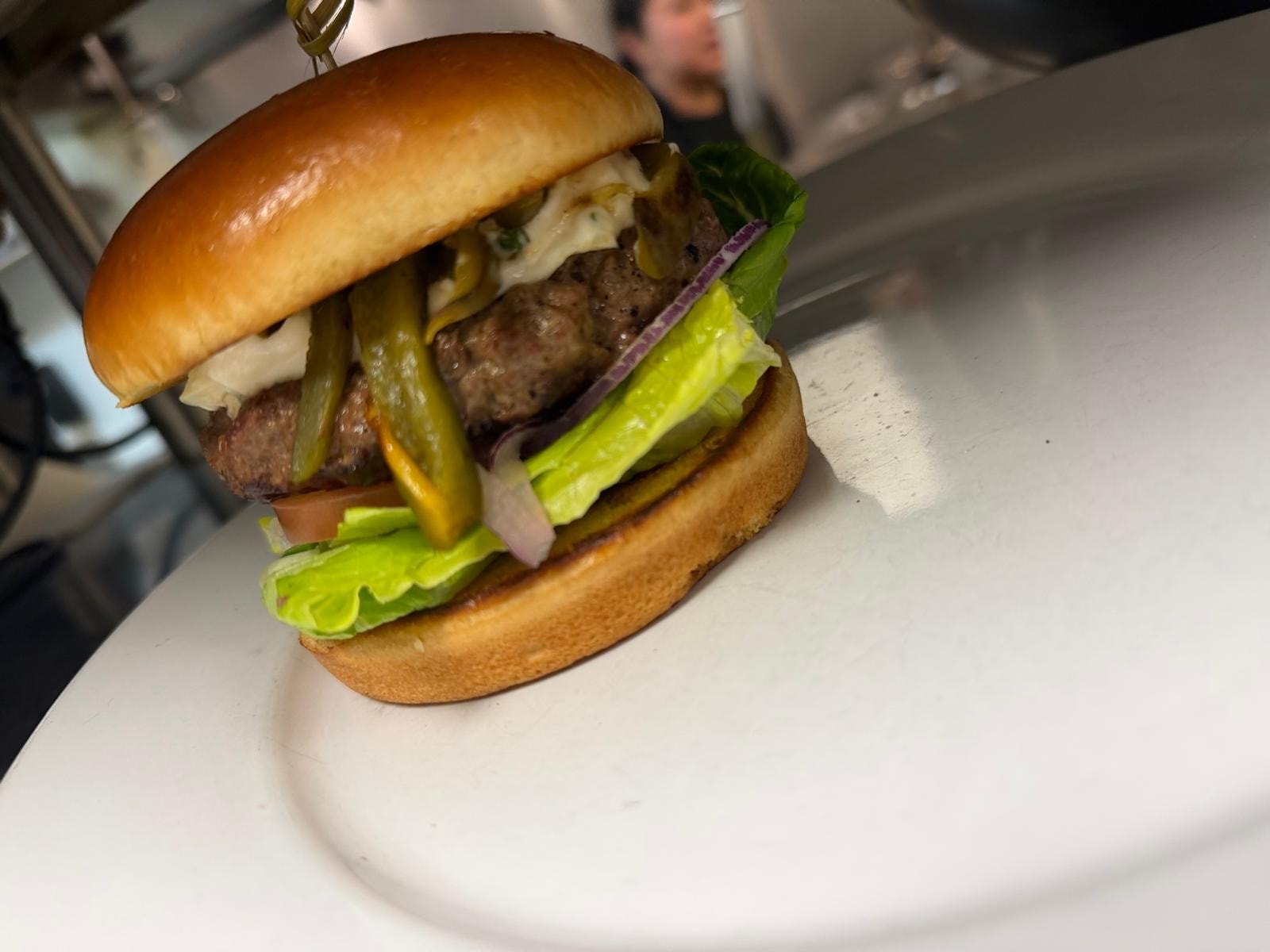 Green chile burger with lettuce and pickled peppers at Westrail